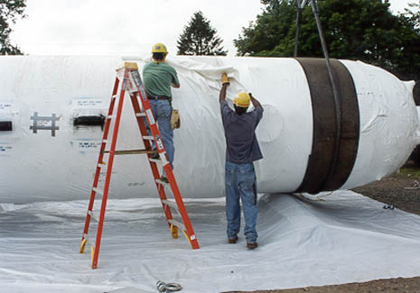Workers handling the covering on the pressurizer