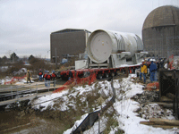Truck backing the pressure vessel canister onto a transport barge